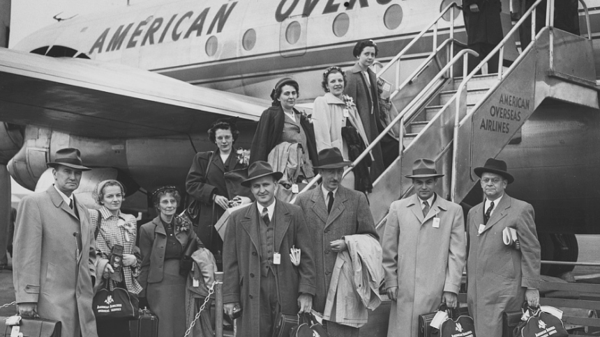 old photo of people standing outside a plane